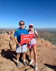 A couple celebrates reaching the Camelback Mountain summit with summit flag made by 5ummit 5omething