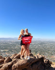 Two girls pose with their orange summit flag to celebrate reaching Camelback Mountain summit - Made by 5ummit Something also known as 5ummit 5omething