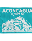 A rectangular turquoise summit flag featuring a white illustrated mountain and large text reading 'ACONCAGUA 6,962 M' with smaller text 'SEVEN SUMMITS - HIGHEST PEAK IN THE AMERICAS' and 'SUMMIT SOMETHING' at the bottom.
