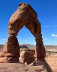 Familiy posing at the base of Delicate Arch in Arches National Park near Moab,  Utah