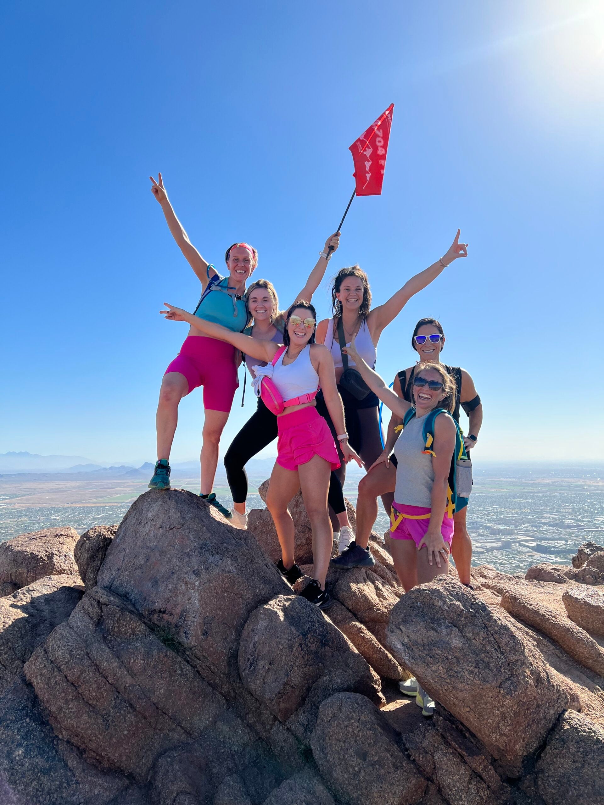 Summit Photo displaying hikers celebrating  reaching Camelback Mountain summit with a 5ummit 5omething summit flag.