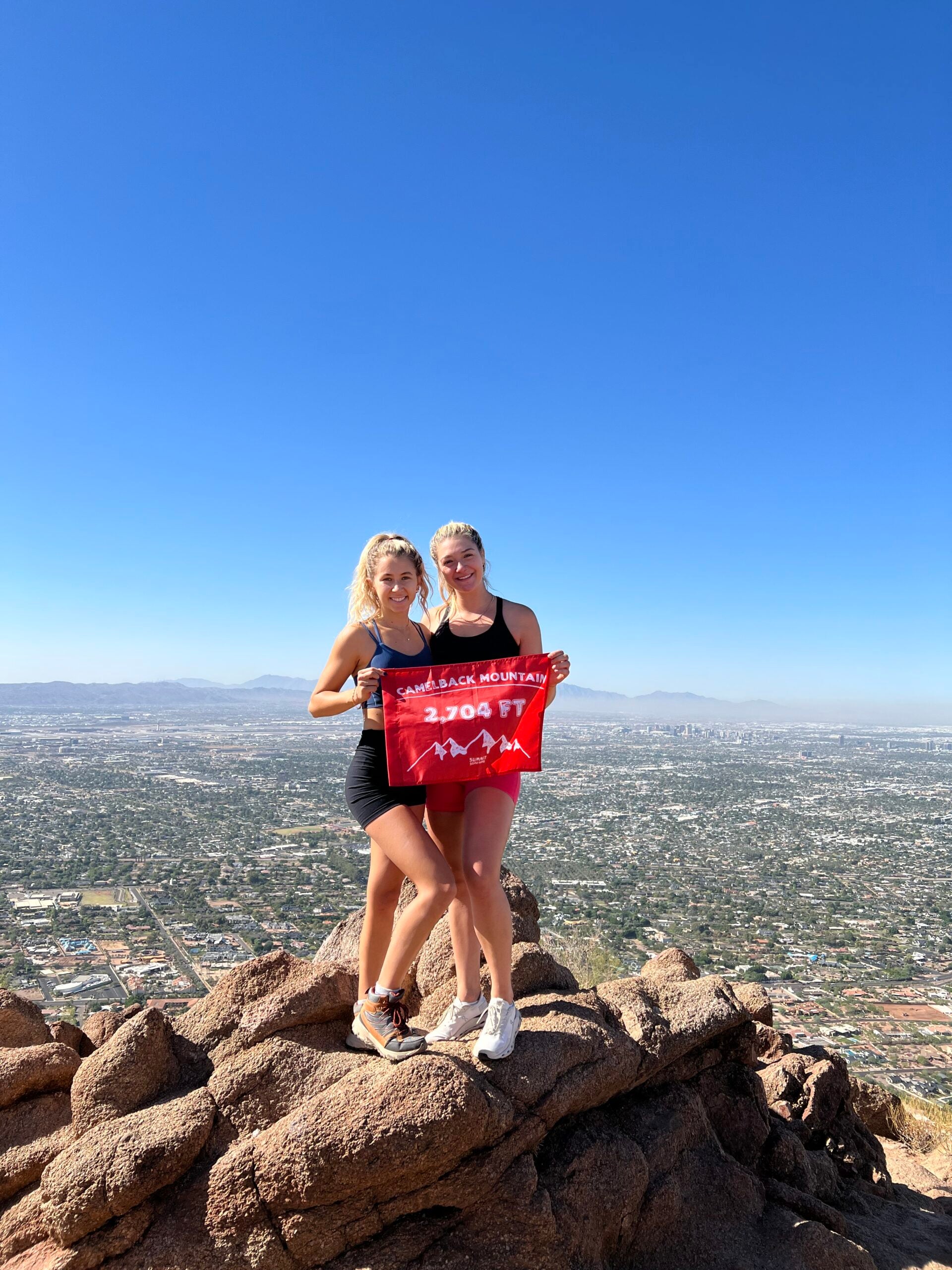 Two girls pose with their orange summit flag  to celebrate reaching Camelback Mountain summit - Made by 5ummit Something also known as 5ummit  5omething