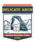 Sticker depicting the majestic Delicate Arch in Arches National Park.  Artwork on the sticker reads Delicate Arch at the top and Arches National Park at the bottom.  Scenery is beautiful capturing the reddish brown colors of the lanscape with mountains and setting sun in the background.